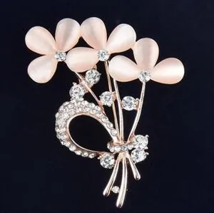 Vue détaillée d'une broche fleur en or rose avec pétales en opale rose et cristaux
