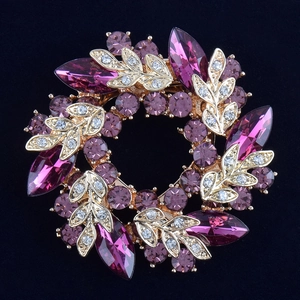 Vue détaillée de la broche couronne avec cristaux violets et feuilles plaquées or