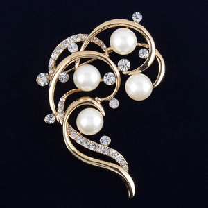Detail einer eleganten goldenen Brosche mit weißen Perlen und funkelnden Straßsteinen