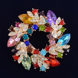 Gros plan détaillé d'une broche florale dorée avec cristaux multicolores sur fond noir