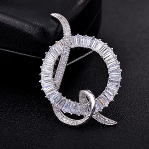 Eleganter silberner Ring-Brosche mit Zirkonia-Kristallen auf schwarzem Lederhintergrund