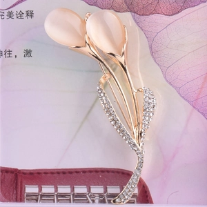 Détail de la broche tulipe dorée avec pierres œil de chat roses et zircons