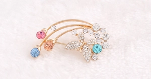 Dettaglio dell'elegante spilla a farfalla con cristalli multicolore su sfondo bianco soffice