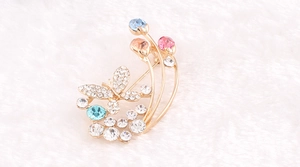Dettaglio macro di un'elegante spilla a farfalla con strass colorati su soffice tessuto