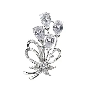 Broche fleur élégante en métal argenté avec zircons en forme de poire et nœud scintillant