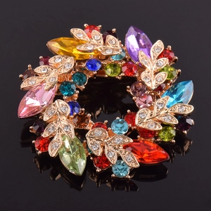 Détail d'une broche couronne florale sertie de cristaux colorés et dorure élégante
