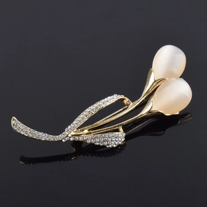 Détail de la broche fleur dorée avec pierres d'opale et petits strass brillants scintillants