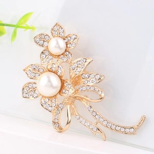 Élégante broche nœud dorée avec perles blanches et cristaux étincelants motif floral