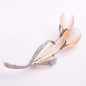 Détail d'une broche tulipe avec pierres œil de chat blanches et strass étincelants