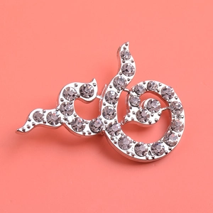 Silver-plated abstract ribbon brooch with sparkling rhinestones on a pink background
