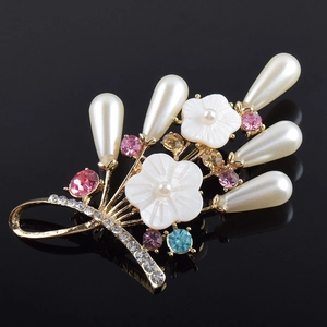 Detail einer floralen Legierungsbrosche mit weißen Muschelblüten, Perlen und Strass