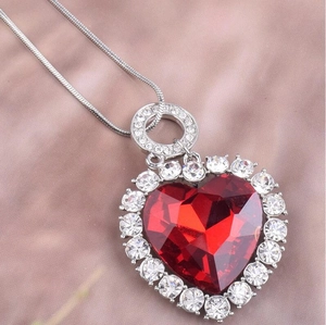 Gros plan détaillé du pendentif coeur en cristal rouge sur une chaîne en argent
