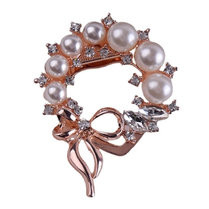 Elegant rose gold wreath brooch with white pearls and sparkling crystals on white background