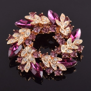Vue détaillée d'une broche couronne dorée avec des cristaux violets de taille marquise