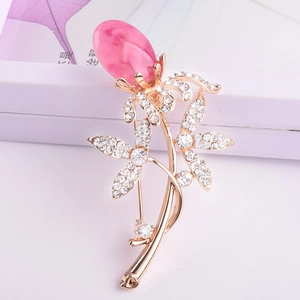 Elegante goldene Blumenbrosche mit rosa Tropfenstein und funkelnden Kristallblüten