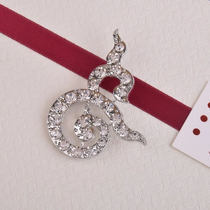 Macro detail of silver Thai number nine brooch with crystals on red ribbon