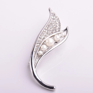 Détail de la broche feuille avec cinq perles blanches et des strass étincelants