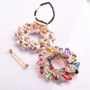 Vue détaillée de la broche couronne dorée avec cristaux multicolores et fermoir clip