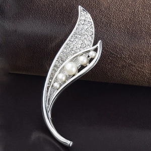 Vue détaillée d'une broche feuille argentée avec 5 perles et strass scintillants