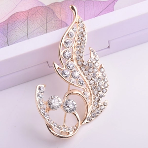 Élégante broche en forme de feuille dorée avec des cristaux brillants au style fluide