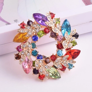 Gros plan détaillé d'une broche florale dorée ornée de cristaux colorés et de strass