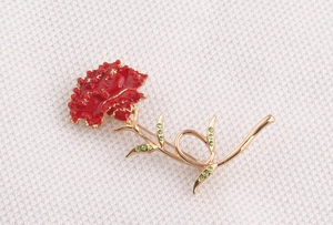 Detailed view of red carnation brooch with enamel petals and sparkling rhinestones