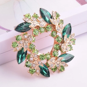 Détail de la broche couronne en cristal vert avec alliage doré et pierres taille marquise