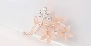 Makroansicht der eleganten Blumenbrosche mit Roségold-Finish und Opal-Blüten