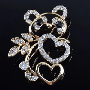 Détail d'une broche panda étincelante avec strass et accents de feuilles de bambou dorées