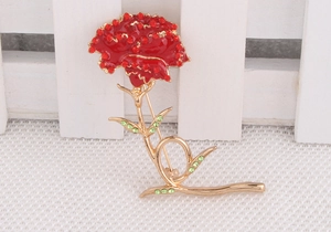 Detailed view of carnation brooch with red enamel and sparkling crystal inlay