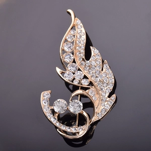 Vue détaillée d'une broche feuille dorée ornée de cristaux blancs scintillants