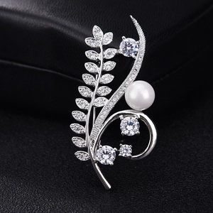 Elegant silver wheat-shaped brooch with white zircons and a pearl on a black display