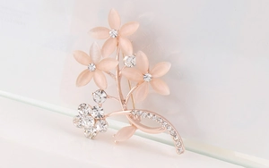Detail der rosa Opal-Blütenblätter und Kristallblätter auf der rotgoldenen Blumenbrosche