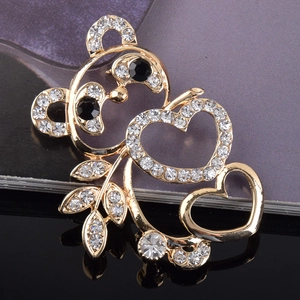 Détail d'une broche panda avec strass étincelants et cœurs décoratifs en finition dorée