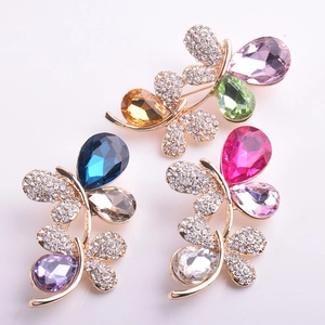 Vue détaillée de broches papillons en cristal aux couleurs vives et base dorée