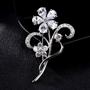 Elegant floral brooch with cubic zirconia crystals in silver finish on black background