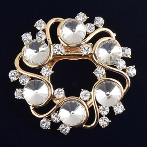 Vue macro d'une broche couronne dorée avec cristaux étincelants sur velours noir