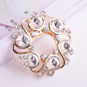 Détail d'une luxueuse broche fleur avec placage à l'or et cristaux clairs de coupe ronde