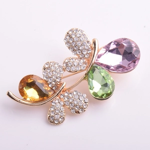 Détail macro de la broche papillon avec cristaux colorés en goutte et micro-pavage de diamants