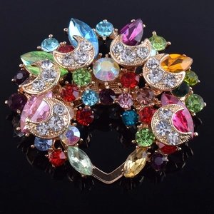 Détail macro d'une broche cœur aux cristaux multicolores et base plaquée or