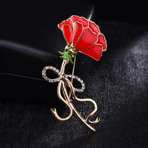 Elegant red carnation brooch with gold accents and sparkling crystals on jewelry case