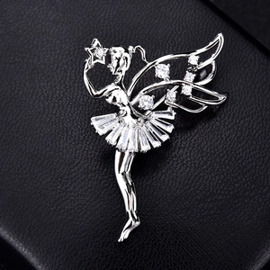 Macro shot of silver ballerina brooch with sparkling cubic zirconia on black leather background