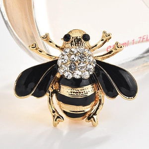 Vue macro d'une broche abeille avec ailes en émail noir et strass en cristal brillant