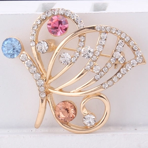 Close-up of colorful crystal butterfly brooch with pink and blue stones in gold setting