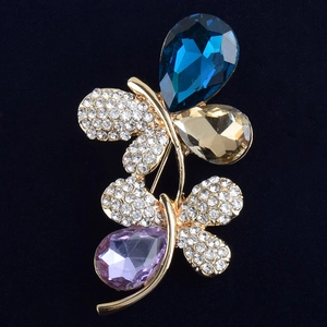 Détail macro d'une broche papillon avec cristaux multicolores et plaqué or