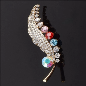 Elegant leaf crystal brooch with colorful gemstones on a golden metal base