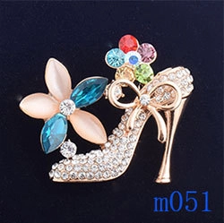 Detailansicht einer funkelnden High-Heel-Brosche mit bunten Strasssteinen und Blumen
