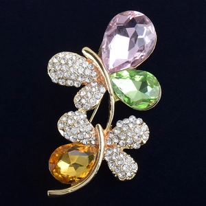 Détail d'une broche papillon avec cristaux multicolores sur fond en velours noir
