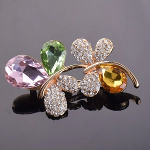 Détail macro d'une broche papillon avec cristaux colorés et finition dorée élégante