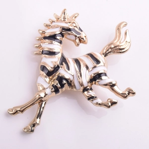 Close-up of zebra brooch with gold alloy base and black and white enamel finish